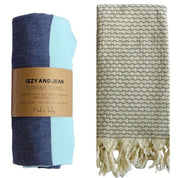 Navy and MInt Santorini Turkish towel with 'Izzy and Jean' label and an Anatolia Turkish towel with a geometric pattern on a white background
