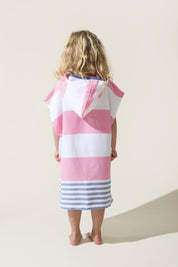 Child wearing a pink and blue with white stripes hooded towel on a beige background
