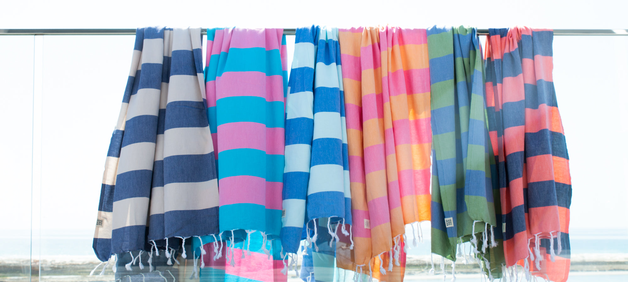 Colorful striped towels hanging on a rack with a blurred background