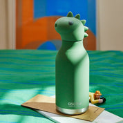 Green dinosaur-shaped water bottle with a silver base on a colorful background