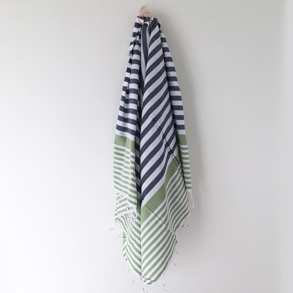 A hanging stylish Turkish towel in blue, white and green stripes.