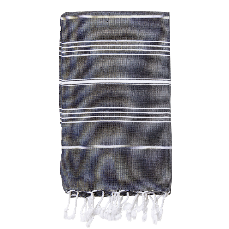 A folded black Turkish towel with white stripes and fringes on the bottom