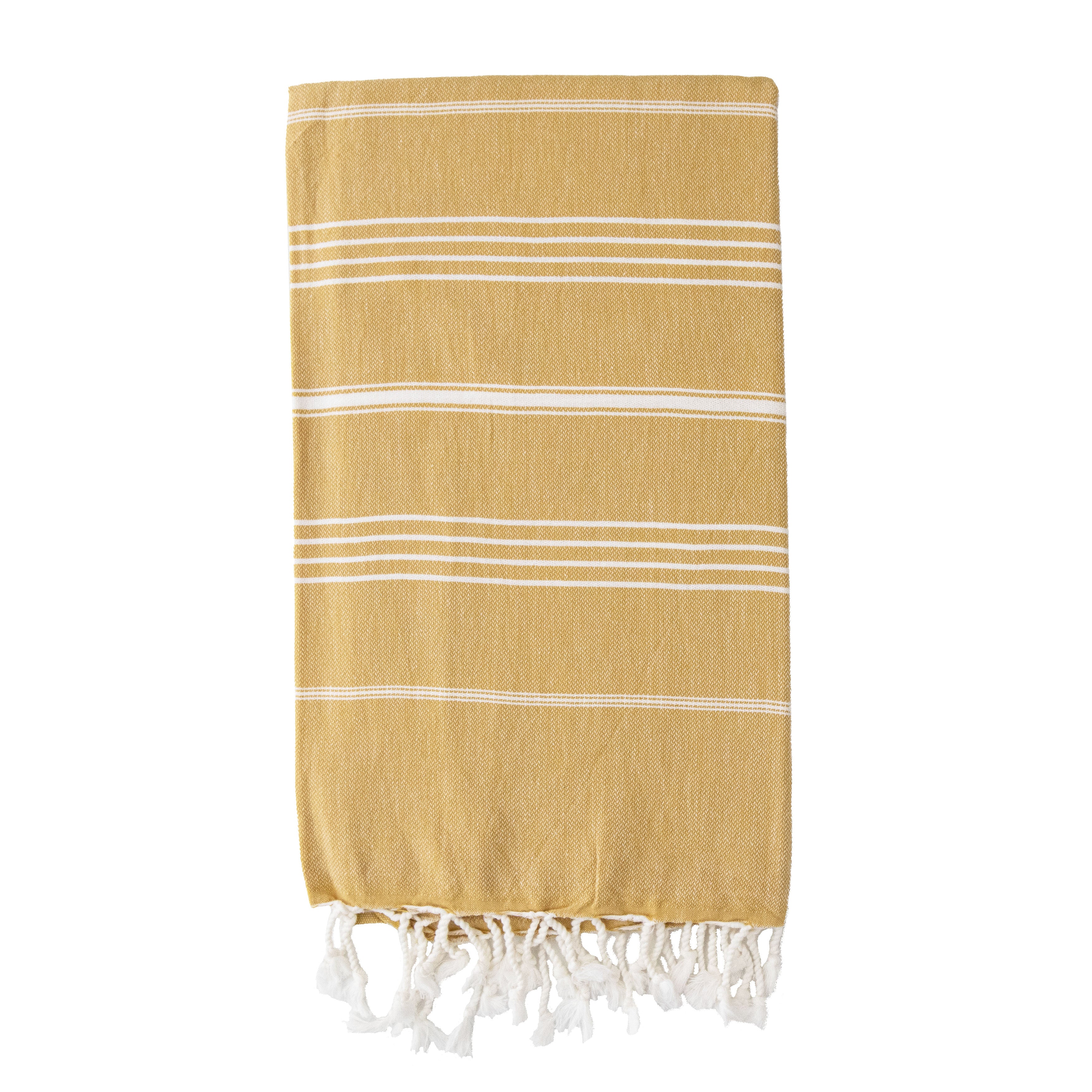  A folded mustard coloured Turkish towel with white striped and tassels at the bottom.