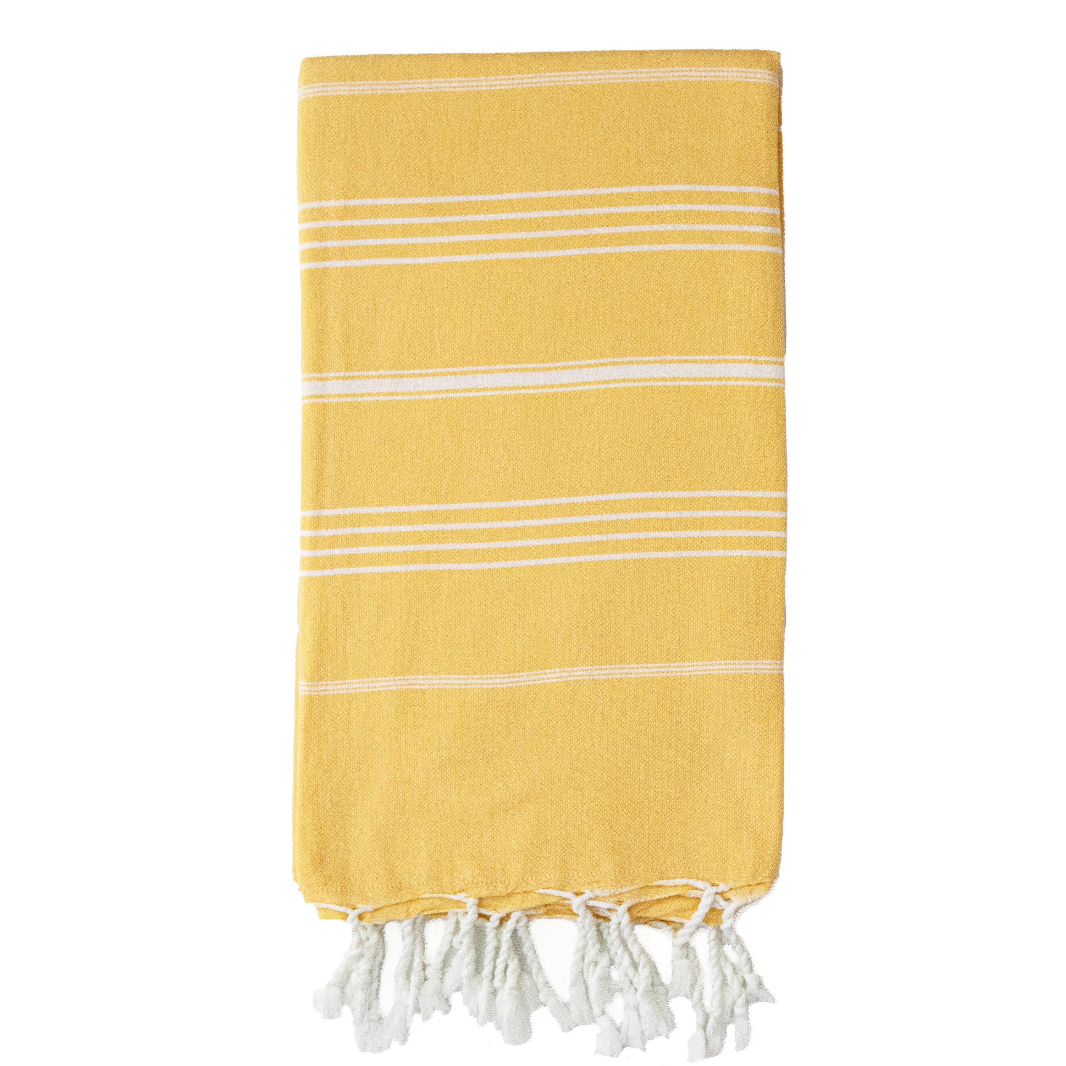 A folded yellow Turkish towel with white stripes and fringes on the bottom