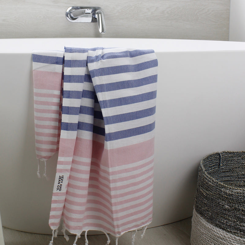 coral and blue and white striped Turkish towels hanging over a bath