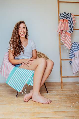 A folded blue, pink and white striped Sofia Turkish towel