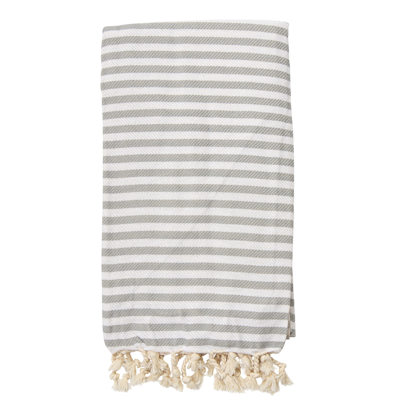 A gray striped St Tropez Turkish towel with white tassels on the ends, displayed on a white background.